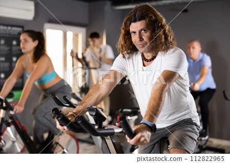 Woman and men doing cardio workout out, training on exercise bike 112822965