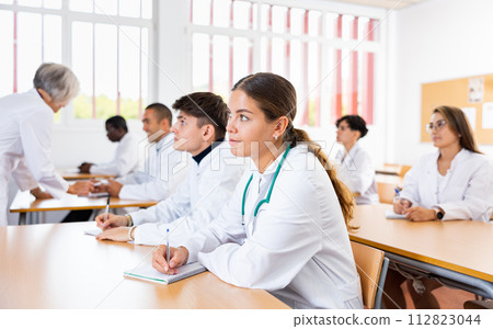 Young girl medical student taking notes during group lecture Young girl medical student taking notes during group lecture 112823044