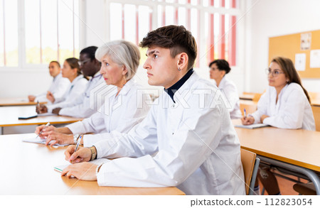 Young doctor trainee listening to lecture during refresher course Young doctor trainee listening to lecture during refresher course 112823054
