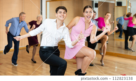 Couple of young dancers rehearsing ballroom dances in dance studio Couple of young dancers rehearsing ballroom dances in dance studio 112823138