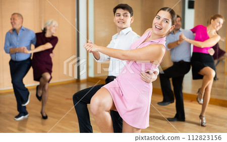 Young pair practicing Latino dance in dance studio Young pair practicing Latino dance in dance studio 112823156