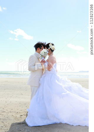 Photo wedding of the bride in a wedding dress and the groom in a tuxedo, location shooting at the sea Photo wedding of the bride in a wedding dress and the groom in a tuxedo, location shooting at the sea 112823166