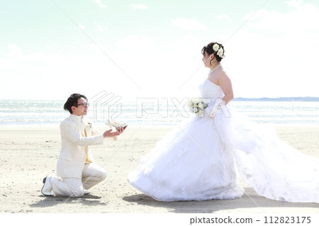 新娘穿著婚紗和新郎穿著燕尾服的婚禮照片，在海邊拍攝 112823175