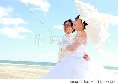 新娘穿著婚紗和新郎穿著燕尾服的婚禮照片，在海邊拍攝 112823182