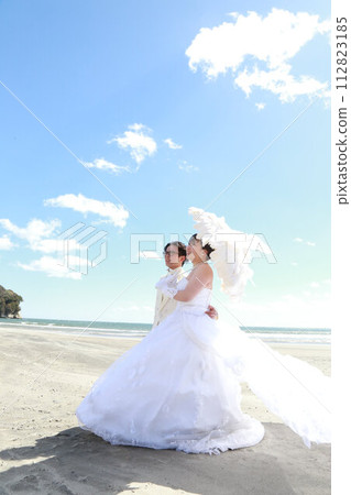 新娘穿著婚紗和新郎穿著燕尾服的婚禮照片，在海邊拍攝 112823185