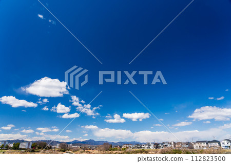 White clouds floating in the spring blue sky and residential area 112823500