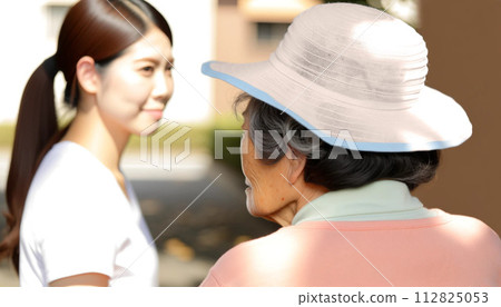 一名菲律賓女護理員在散步時照顧一名日本老年婦女。 一名菲律賓女護理員在散步時照顧一名日本老年婦女。 112825053