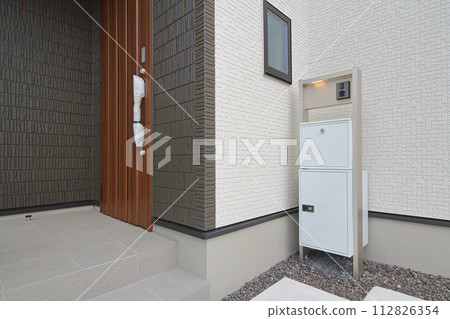 Delivery box installed at the entrance of a house Delivery box installed at the entrance of a house 112826354