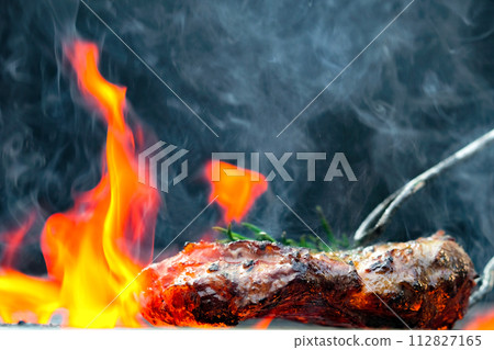 Grilled steak meat on the grill of the grill that has a flame Grilled steak meat on the grill of the grill that has a flame 112827165