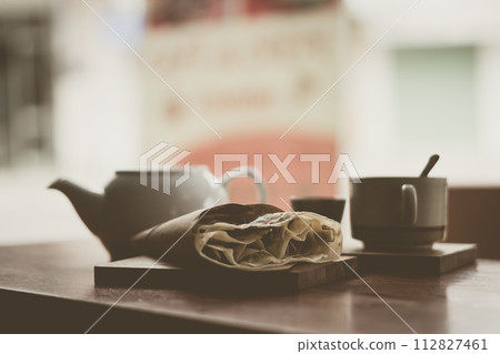 Mental warmth comfort calm silence. Breakfast cafe. Vintage matte photo. Ceramic kettle mug, large pancake on wooden board Mental warmth comfort calm silence. Breakfast cafe. Vintage matte photo. Ceramic kettle mug, large pancake on wooden board 112827461
