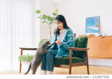 A woman who plays with a cat A woman who plays with a cat 112827502