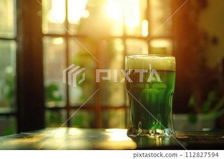 A glass of green beer on a table in a pub. St Patrick's day, holidays and celebration concept 112827594