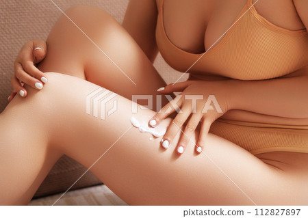 Cropped image of woman in lingerie applying cream 112827897