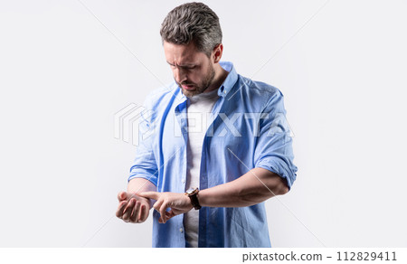 photo of man measuring pulse on wrist. mature man with pulse on wrist. man check pulse on wrist 112829411