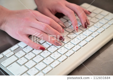 Typing on the keyboard with nailed hands 112831684