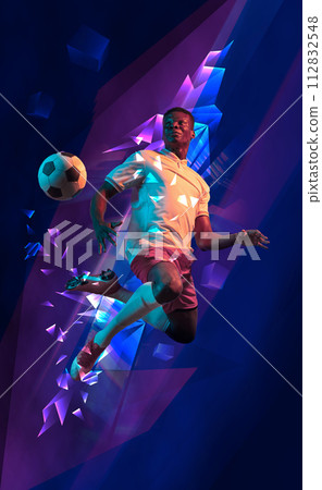 Dynamic image of young African man, football player in motion during game match, hitting ball against dark background with polygonal and fluid neon elements. 112832548