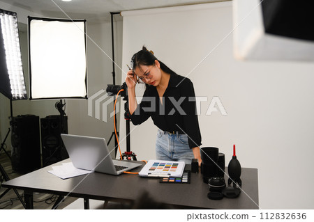 Frustrated female photographer working at her studio 112832636