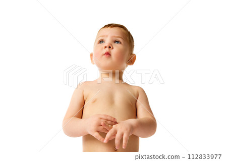 Adorable little baby boy, child with blushing cheeks standing with calm and curious face isolated over white studio background Adorable little baby boy, child with blushing cheeks standing with calm and curious face isolated over white studio background 112833977