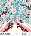 Close-up of hands toasting under a cherry blossom tree in full bloom 112834695