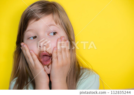 Frightened little girl eating chocolate dirty face 112835244