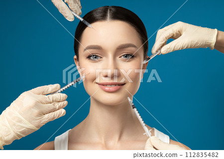 The doctor injects botox to a young girl The doctor injects botox to a young girl 112835482