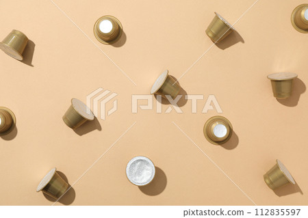 Golden coffee capsules on beige background, top view 112835597