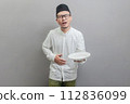Asian Muslim man holding back hunger and plate 112836099