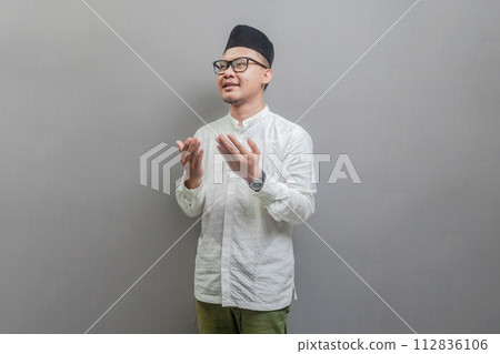Asian Muslim man standing looking empty space happily to show grateful 112836106