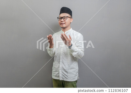 Asian Muslim man standing looking empty space happily to show grateful 112836107