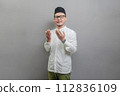 Asian Muslim man standing looking empty space happily to show grateful 112836109