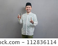 Happy asian muslim man holding glass of pure water give to camera 112836114
