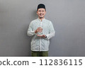 Happy asian muslim man holding glass of pure water give to camera 112836115