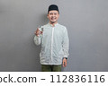 Happy asian muslim man holding glass of pure water give to camera 112836116
