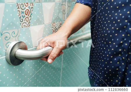 Asian woman patient use toilet support rail in bathroom, handrail safety grab bar, security in nursing hospital. Asian woman patient use toilet support rail in bathroom, handrail safety grab bar, security in nursing hospital. 112836660