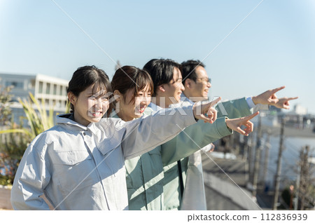 四位年輕工程師，男性和女性，指著 112836939