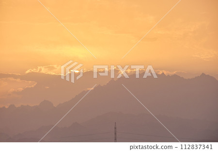 Sunset landscape with dark mountain peaks in egyptian desert Sunset landscape with dark mountain peaks in egyptian desert 112837341