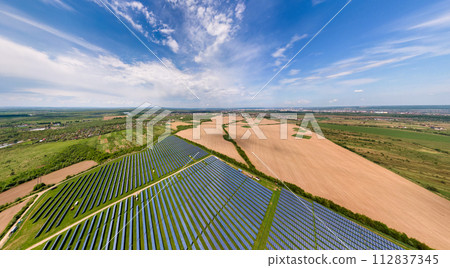 Aerial view of big sustainable electric power plant with many rows of solar photovoltaic panels for producing clean ecological electrical energy. Renewable electricity with zero emission concept. 112837345