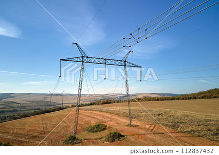 Steel pillar with high voltage electric power lines delivering electrical energy through cable wires on long distance 112837432