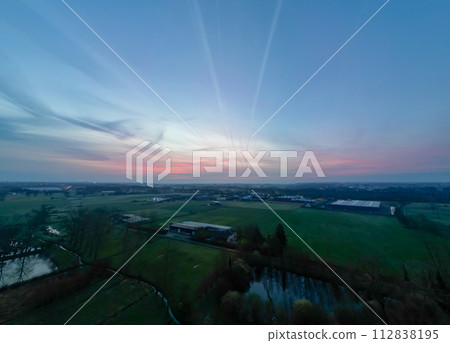 Sunset Over Industrial Harmony: A Tranquil End to a Day in Agriculture 112838195