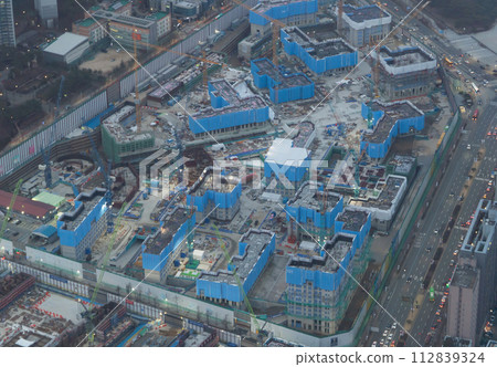 Aerial view of busy industrial construction site workers with cranes working. Top view of development high rise architecture building. 112839324