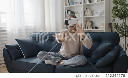 Excited teenager in vr goggles touching space with hands, playing simulation game, augmented reality Excited teenager in vr goggles touching space with hands, playing simulation game, augmented reality 112840676