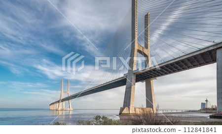 Vasco da Gama bridge timelapse hyperlapse with water in river and blue cloudy sky. Lisbon, Portugal. 112841841