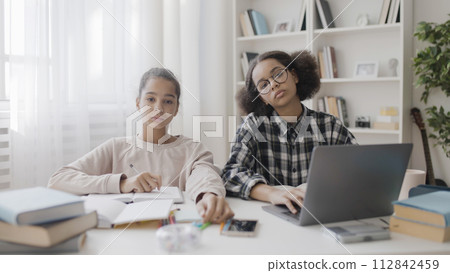 Overwhelmed school pupils looking at camera, studying at home during lockdown Overwhelmed school pupils looking at camera, studying at home during lockdown 112842459