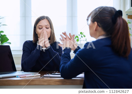 Sad, upset young woman patient at mental therapy session with psychologist 112842627