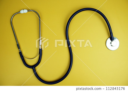 Stethoscope top view on yellow background 112843176