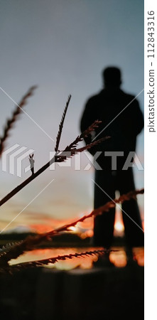 A man standing at the edge of the twilight in a portrait style in an aesthetic blur image 112843316