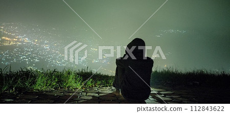 A man on the edge of town at night with a simple expression on his face A man on the edge of town at night with a simple expression on his face 112843622