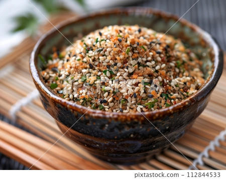 Furikake is a Japanese seasoning made from a mixture of dried and ground ingredients in bowl Furikake is a Japanese seasoning made from a mixture of dried and ground ingredients in bowl 112844533