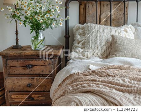Close up of bedside cabinet near bed with beige bedding. 112844728