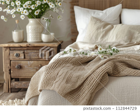 Close up of bedside cabinet near bed with beige bedding. 112844729